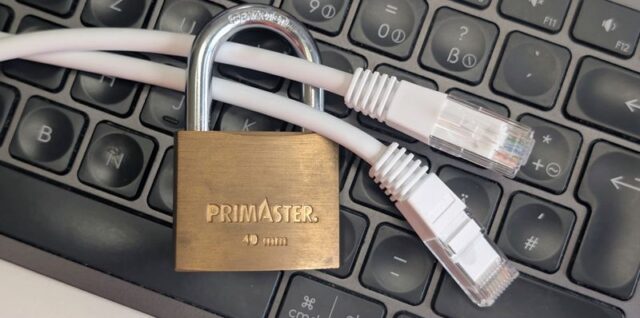 Messingschloss umschließt ein weißes LAN-Kabel auf einer Computertastatur als Symbol für IT-Sicherheit